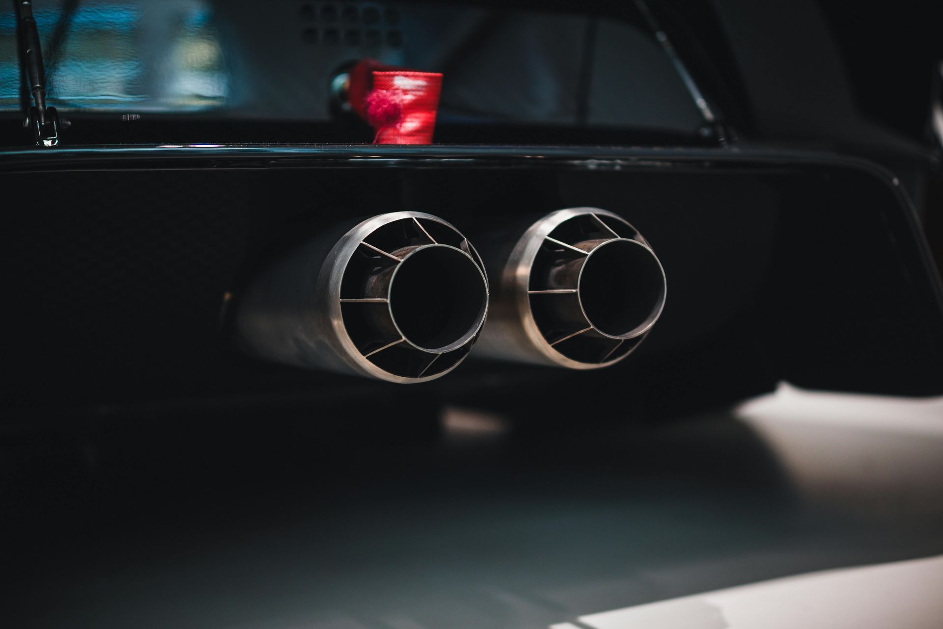 A close up of a car exhaust pipe in a dark room.