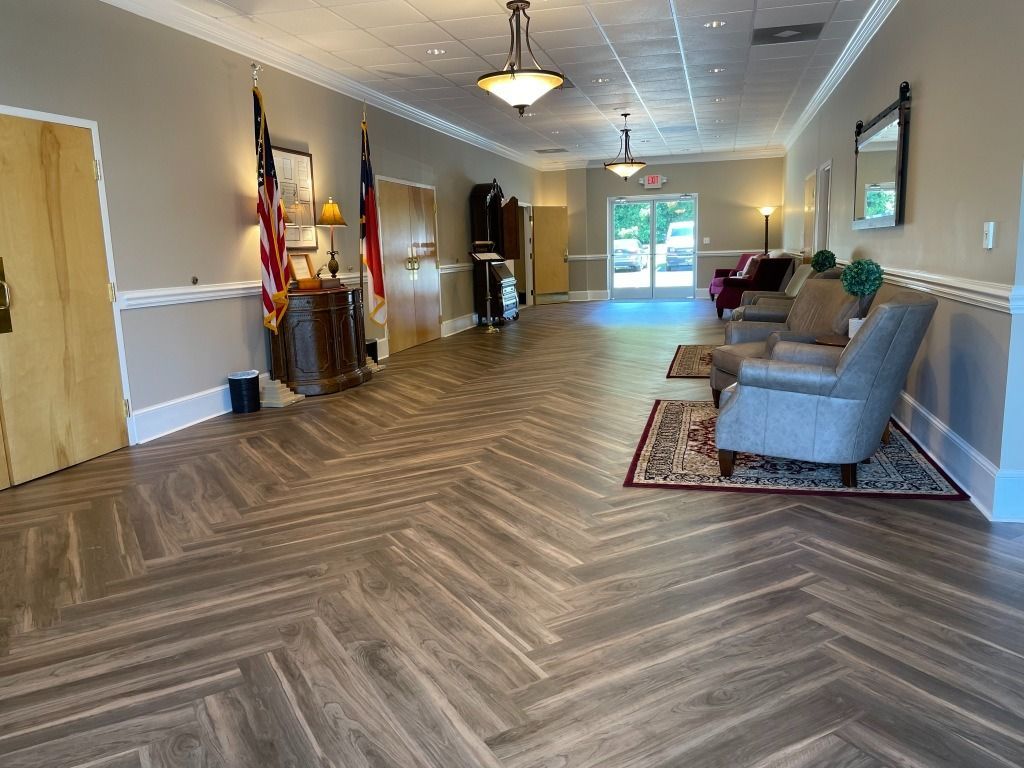 Long hallway with parquet flooring, seating area, and American flag.