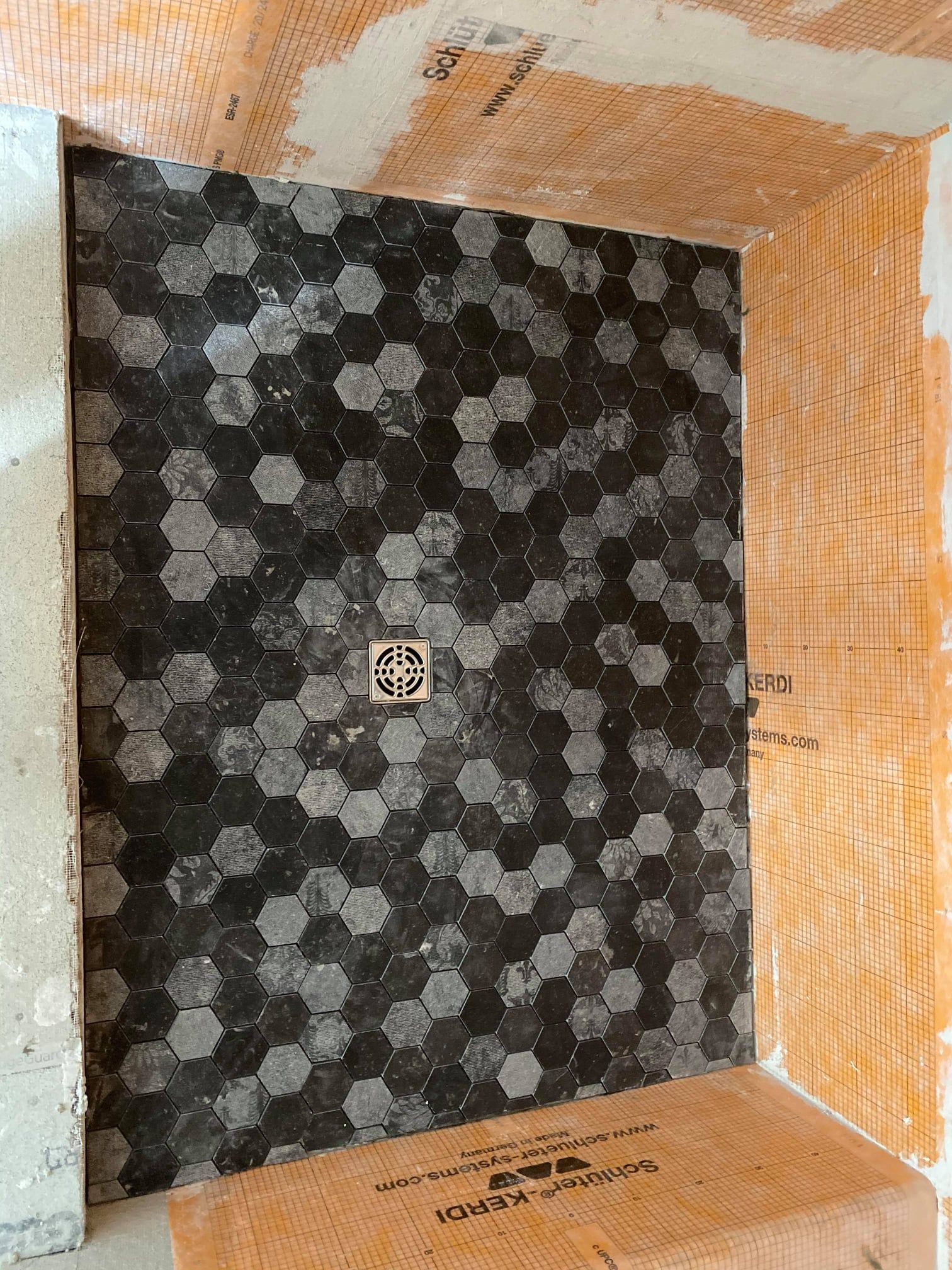 Empty orange crate with a black patterned liner and a small drain in the center.