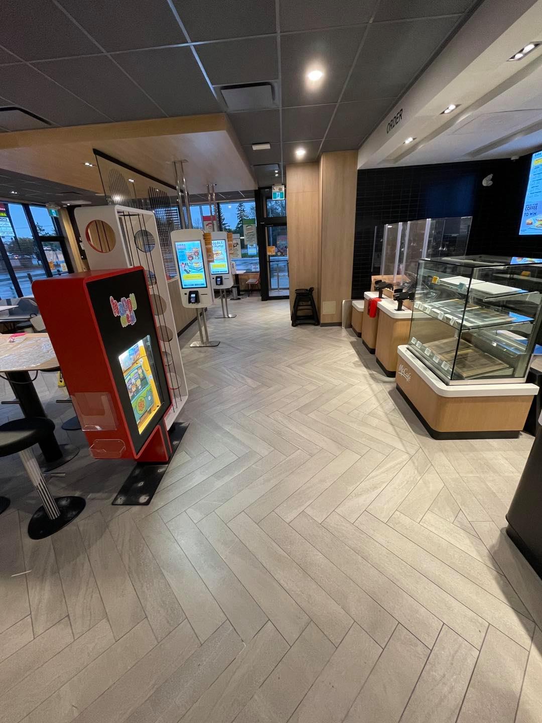 Modern store interior with red vending machine, glass display cases, and overhead lighting