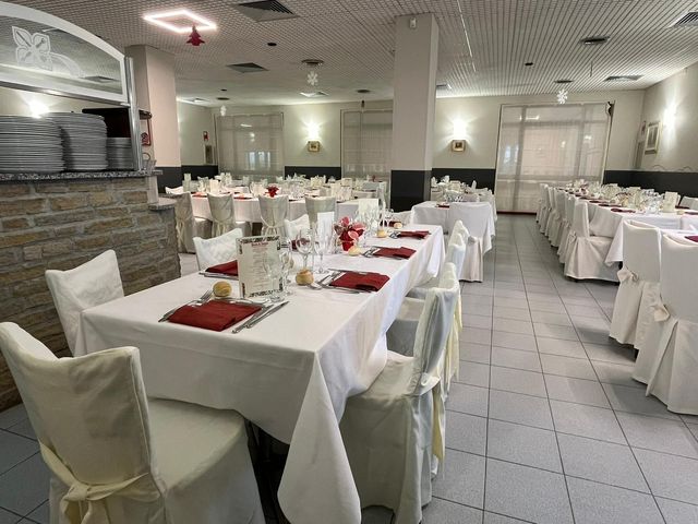Elegante sala da pranzo di un ristorante con tovaglie bianche, tavoli apparecchiati e pavimenti piastrellati.