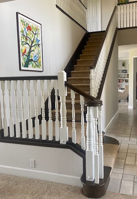 A staircase in a house with a picture on the wall above it.