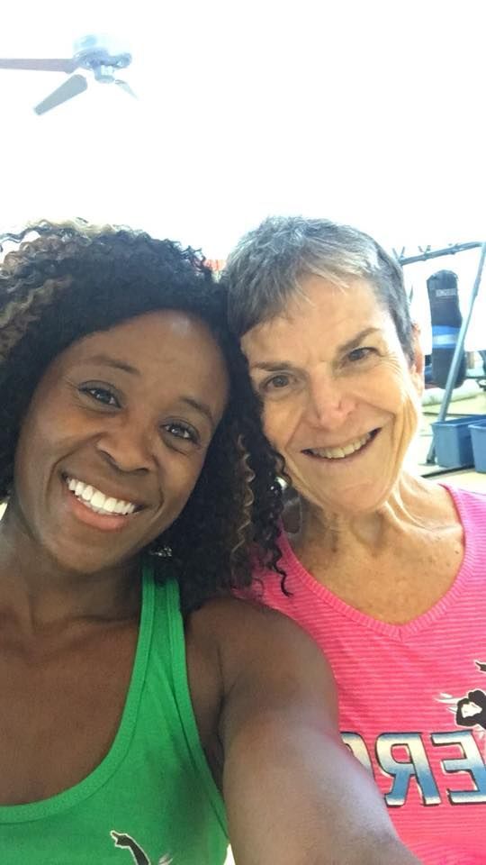 Two women are posing for a picture together and smiling for the camera.