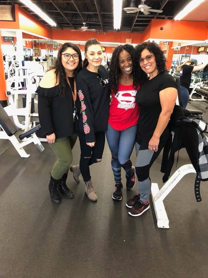 A group of women are posing for a picture in a gym.