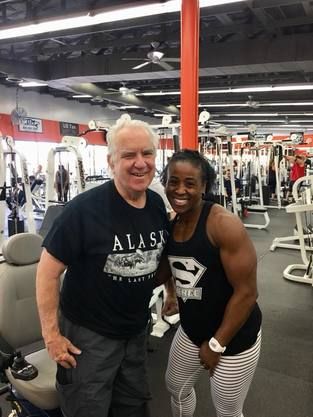 A man and a woman are posing for a picture in a gym.