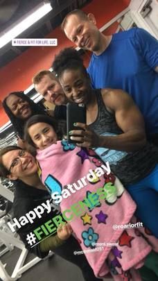 A group of people are posing for a picture in a gym.
