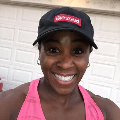 A woman wearing a black hat with the word blessed on it