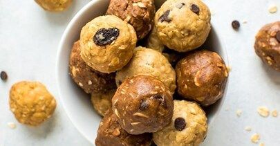 A bowl of cookie dough balls with chocolate chips on a table.
