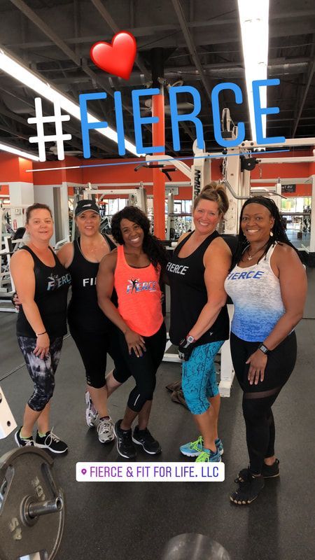 A group of women are posing in Fierce tank tops for a picture in a gym.