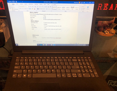 A laptop is open to a word document on the screen