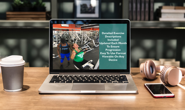 A laptop is open on a wooden desk with headphones and a cell phone to represent online training