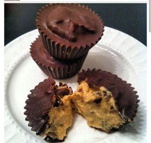 Three peanut butter cups are stacked on top of each other on a white plate