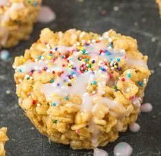 A close up of a rice krispie treat with icing and sprinkles.