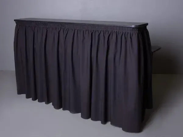 Black skirted table or podium on a plain background