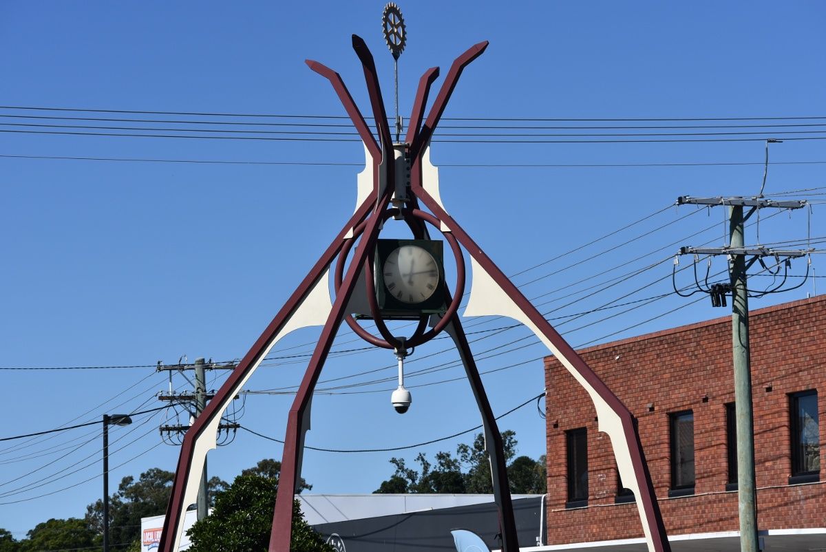 A Statue With a Clock on Top of It in Front of a Brick Building — Leonard Gray Roof Tiling In Ballina, NSW