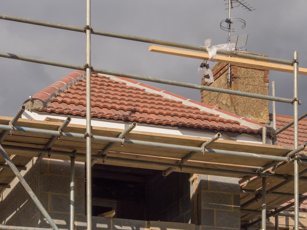 A Building Under Construction With Scaffolding Around It — Leonard Gray Roof Tiling In Goonellabah, NSW