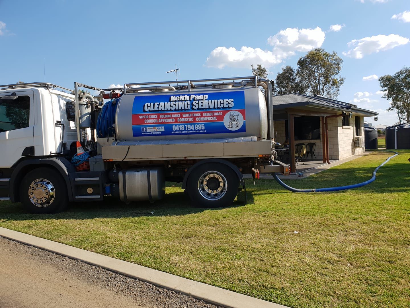 A Septic Tank Cleaning Truck Parked Near a House, Hose Connected — Paap's Cleansing Services in Childers, QLD
