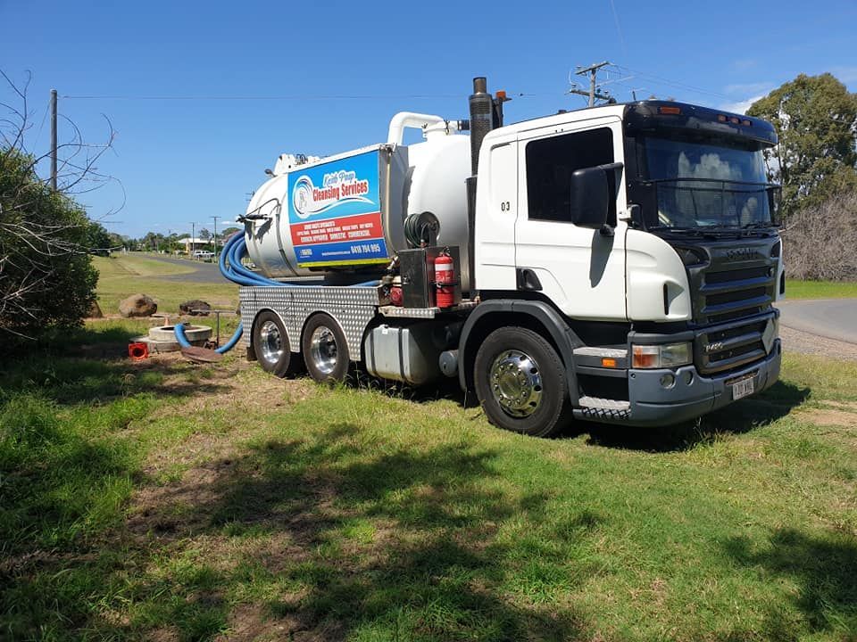 White Septic Truck Parked on Grass, Blue Hose Connected. Sunny Day — Paap's Cleansing Services in Mount Perry, QLD