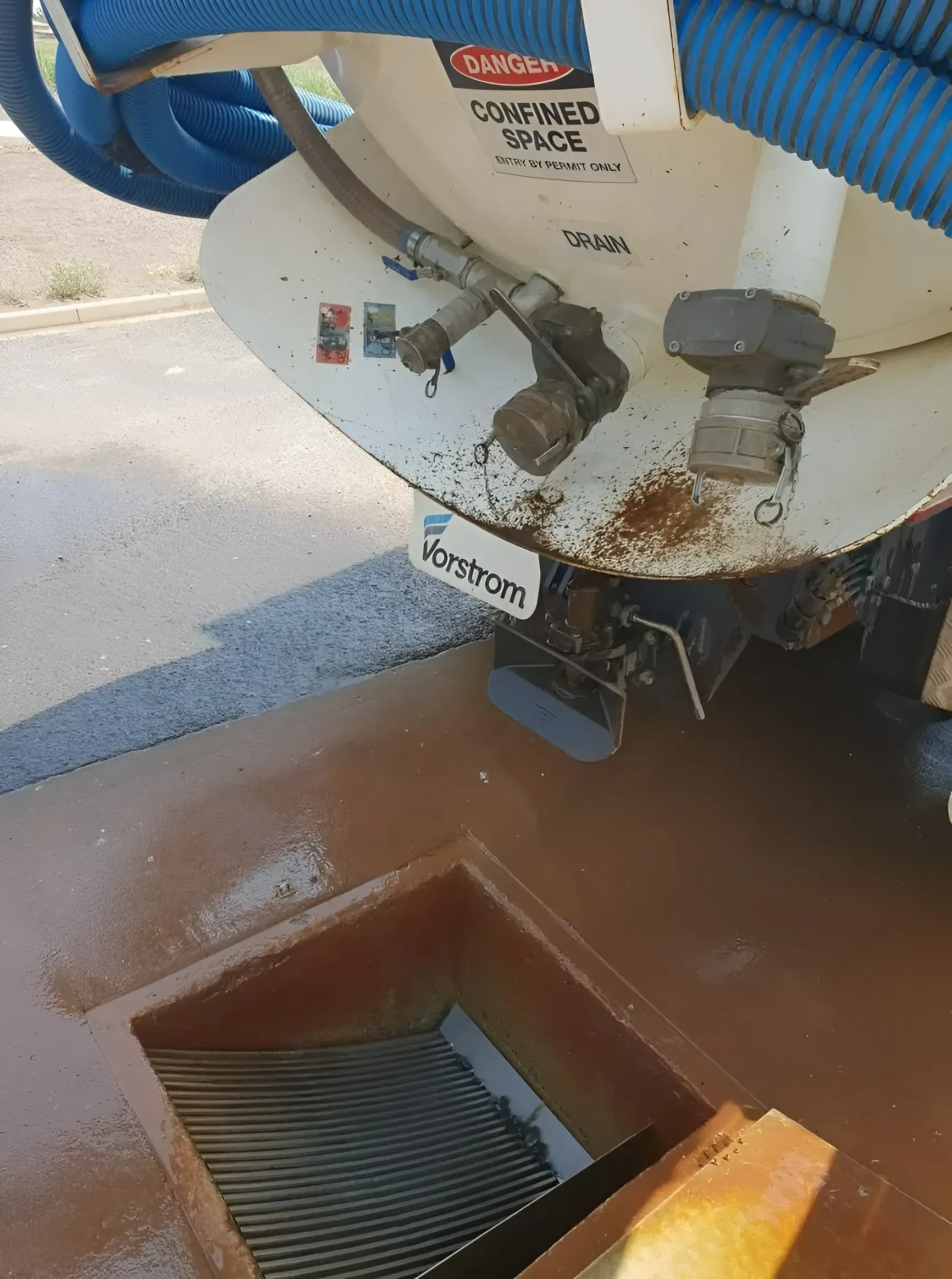 A Septic Truck Emptying Contents Into a Brown Open Grate Drain — Paap's Cleansing Services in Woodgate, QLD