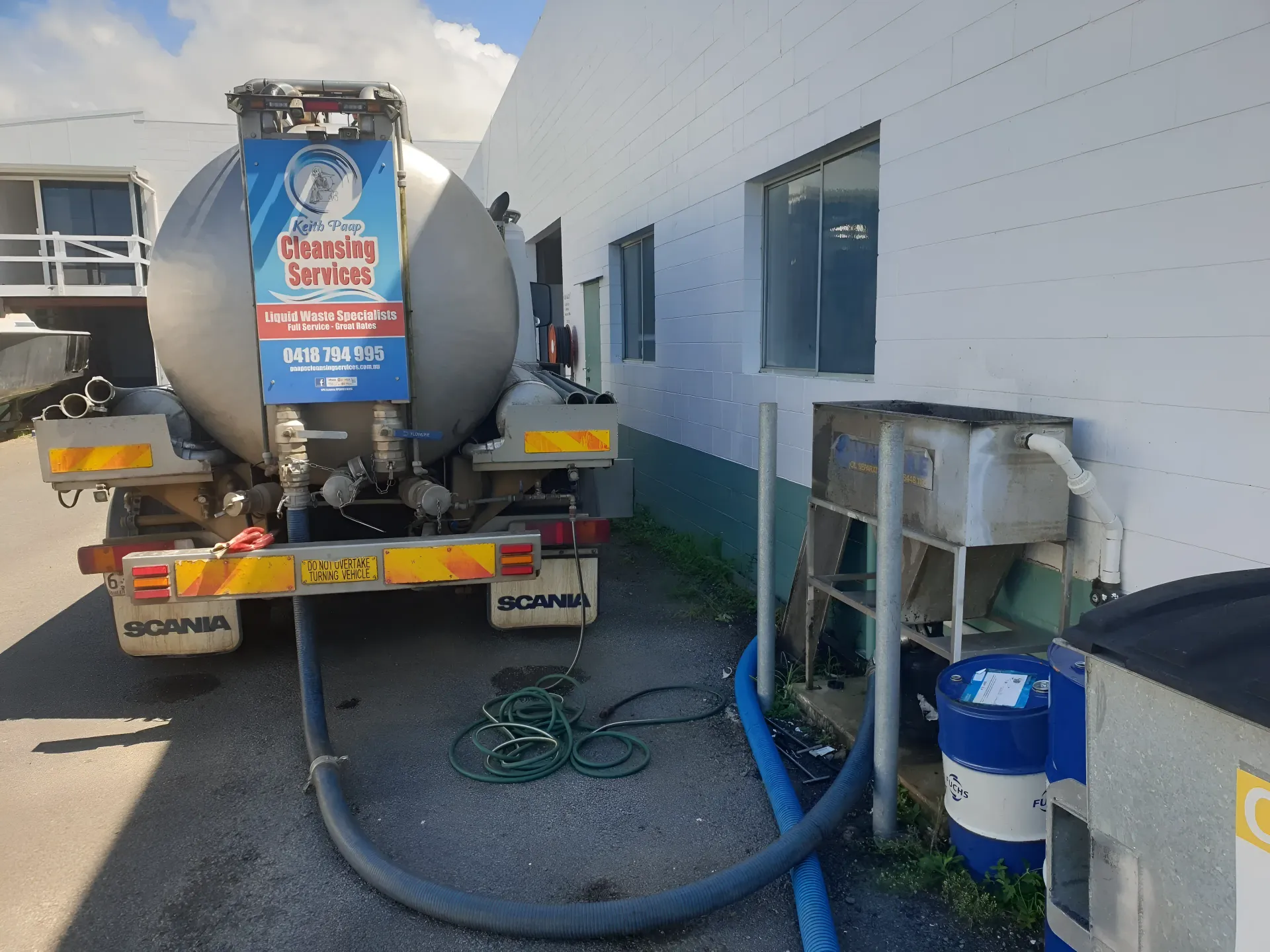 Tanker Truck Parked at a Building, Hose Connected for Liquid Transfer — Paap's Cleansing Services in Branyan, QLD