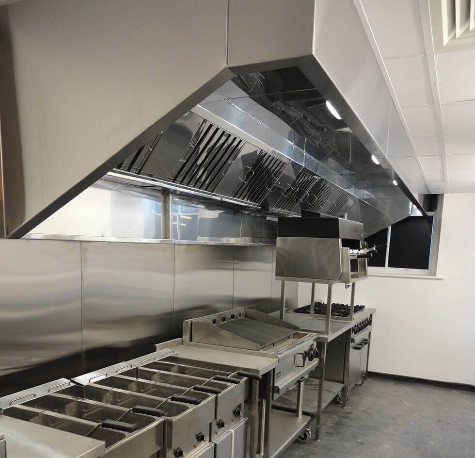 A kitchen with stainless steel appliances and a hood