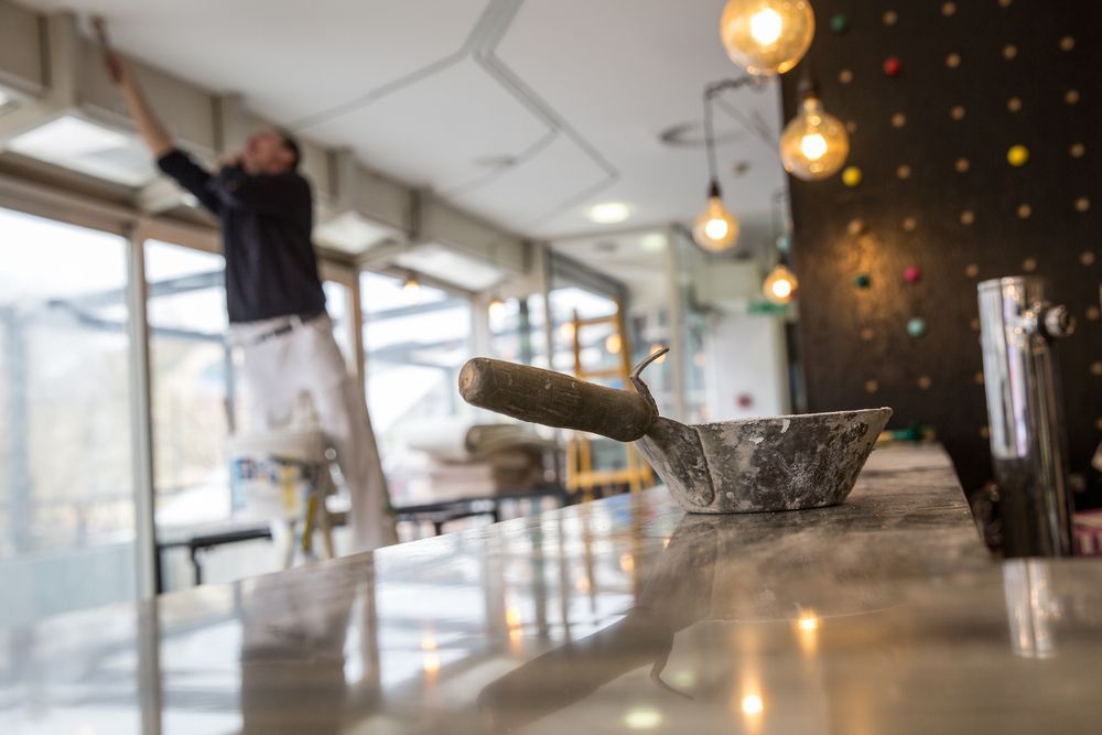 a man is painting the ceiling of a restaurant .
