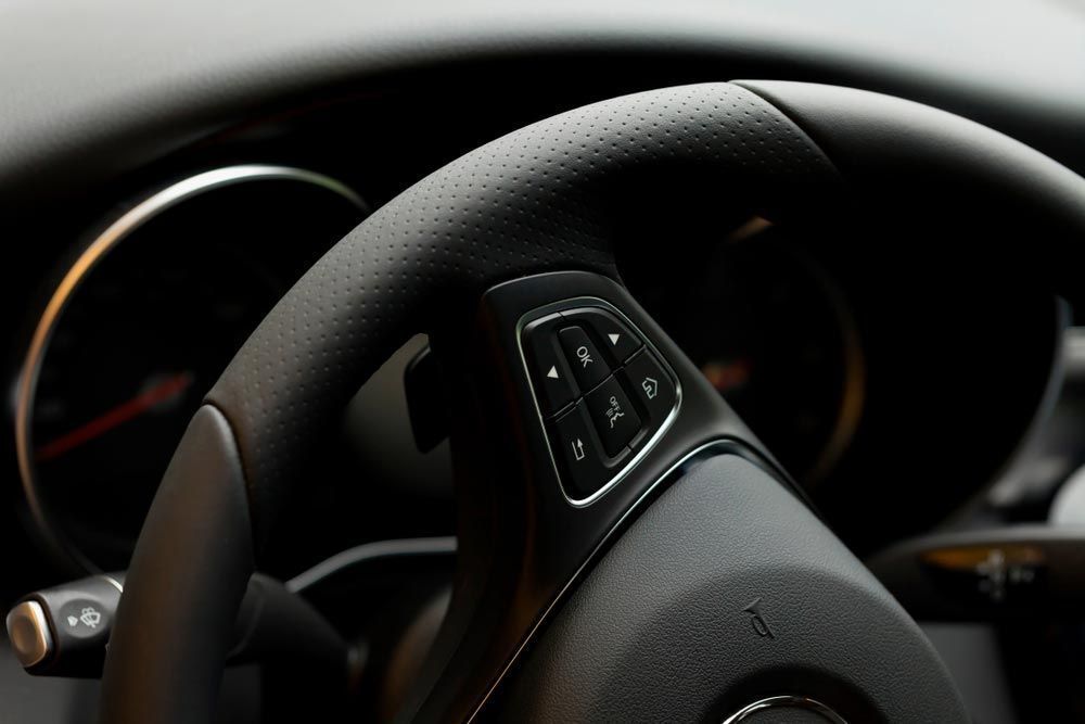 A Black Steering Wheel with Buttons and Perforated Leather — Hervey Bay Brake and Exhaust in Pialba, QLD