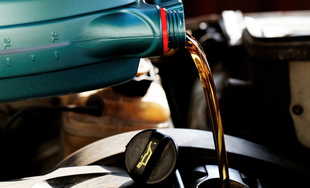 Oil Being Poured Into a Car Engine — Hervey Bay Brake and Exhaust in Pialba, QLD