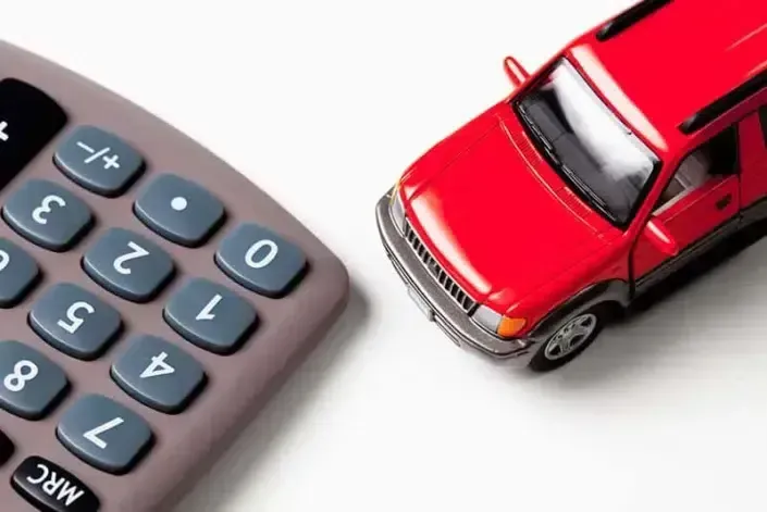 A Calculator Next to A Red Toy Car — HBBE Automotive in Pialba, QLD