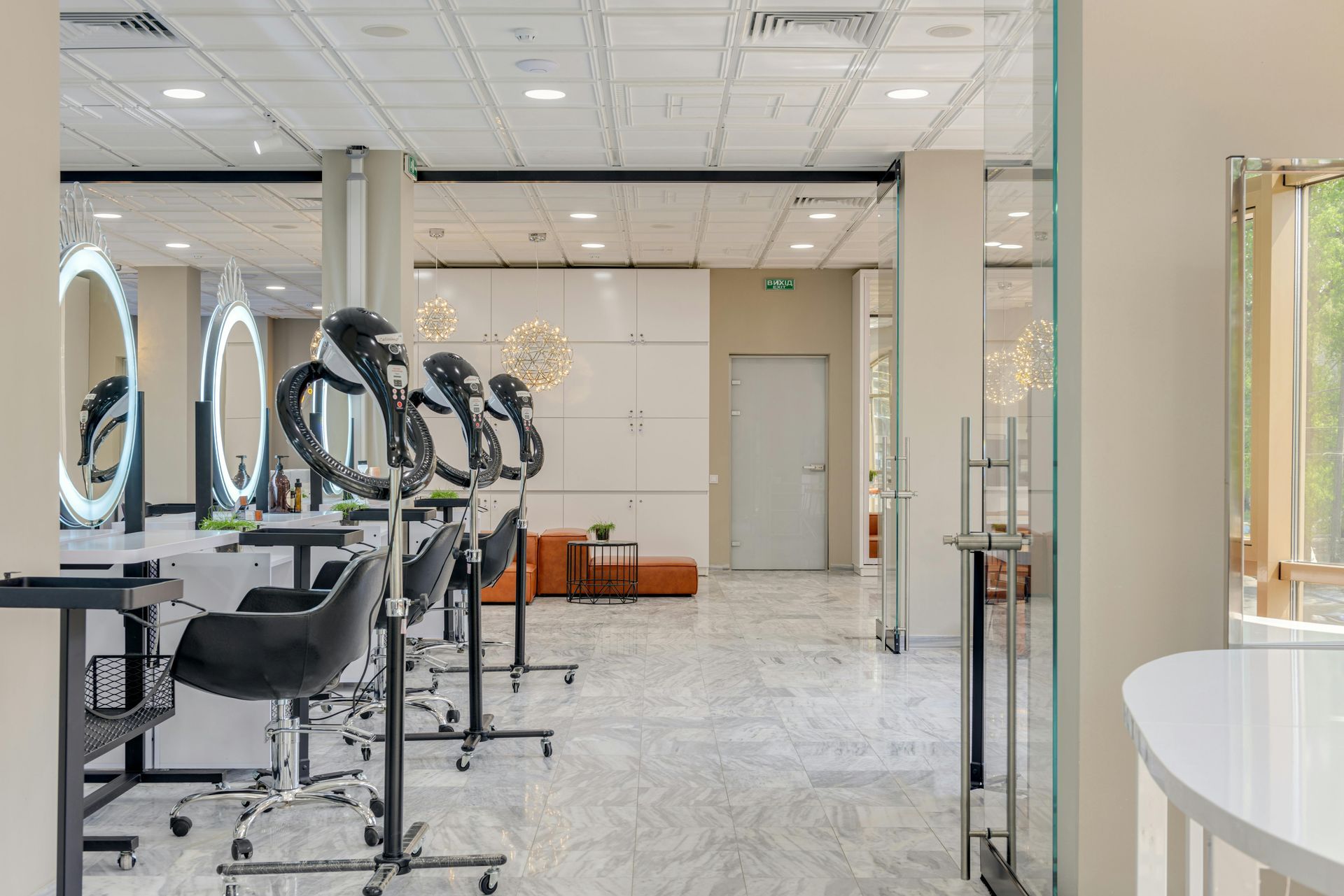 Bright salon with styling chairs, mirrors, and ring lights; white walls and tiled floor.