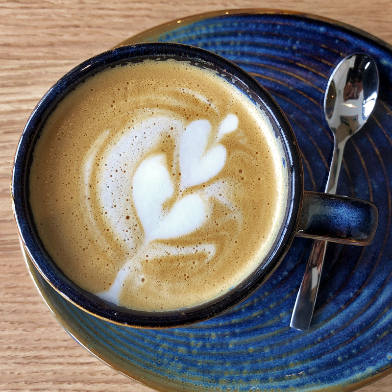 Una taza de café en un platillo con una cuchara.
