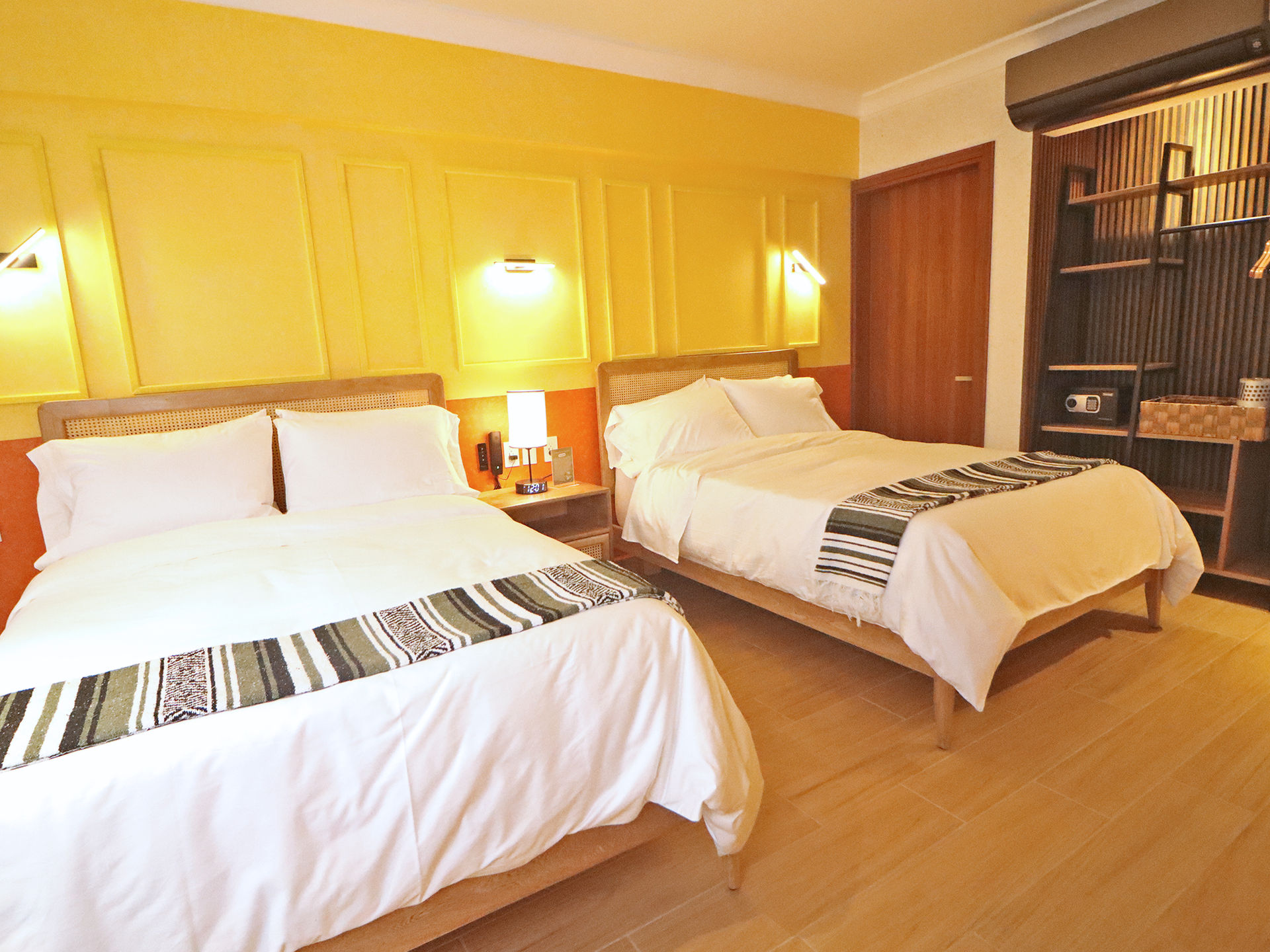 Una habitación de hotel con dos camas y paredes amarillas.