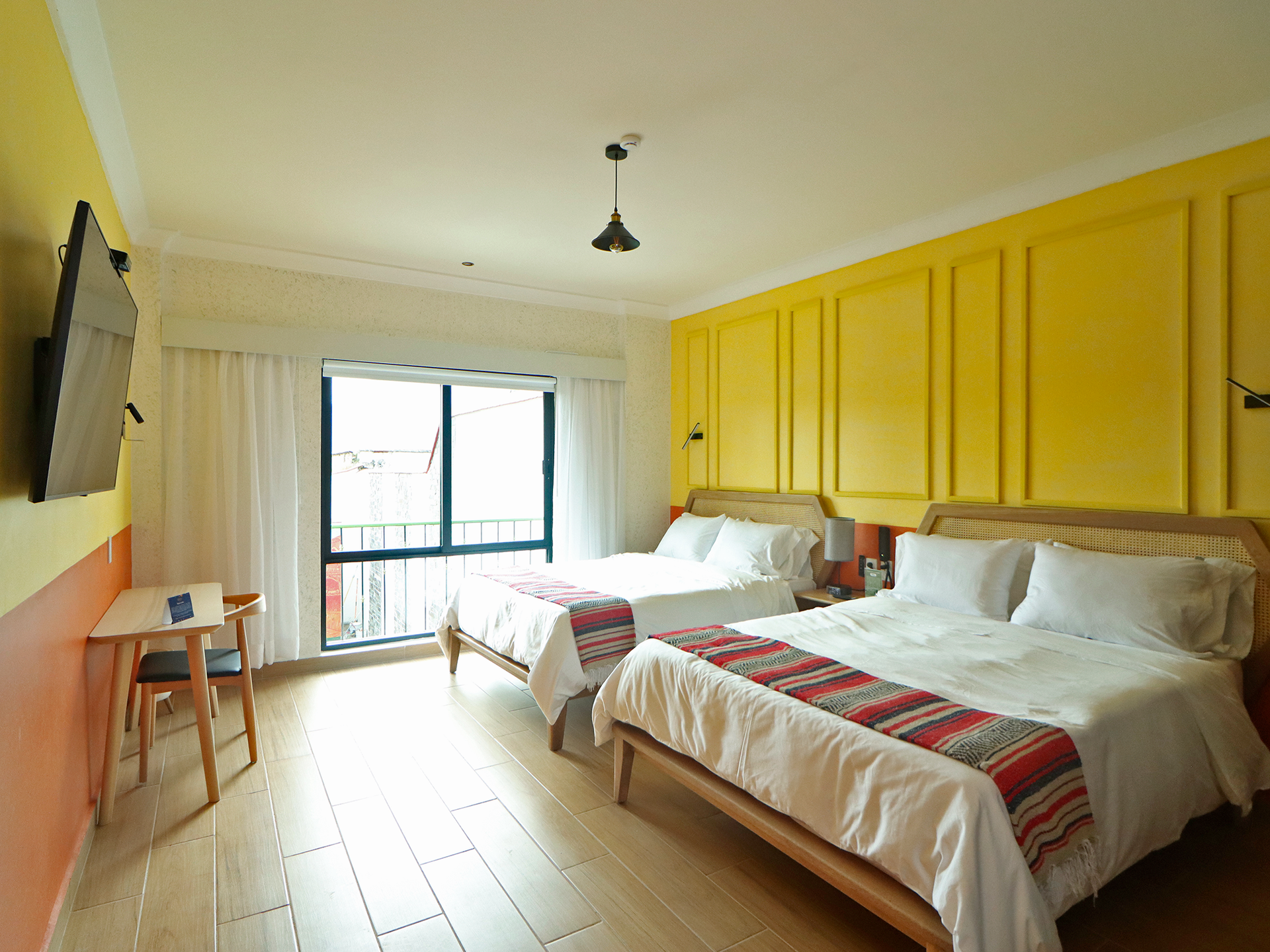 Una habitación de hotel con dos camas y paredes amarillas.