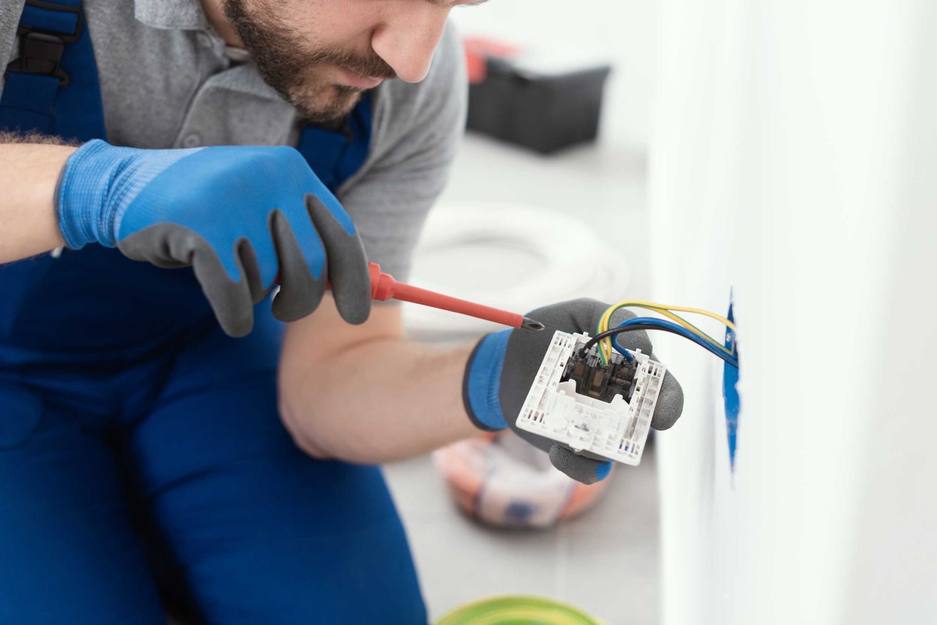 An electrical professional installing a power point wall socket. An electrical professional installing a power point wall socket.