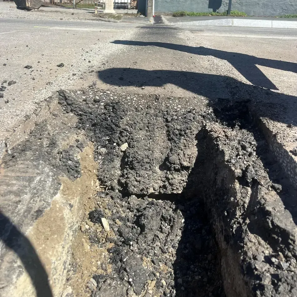 vue de coupe de l'assise et de la couche de roulement d'une chaussée de route départementale pendant une réfection de tranchée en enrobé