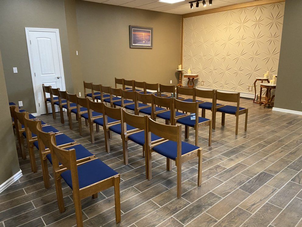A row of wooden chairs in a room with blue seats.