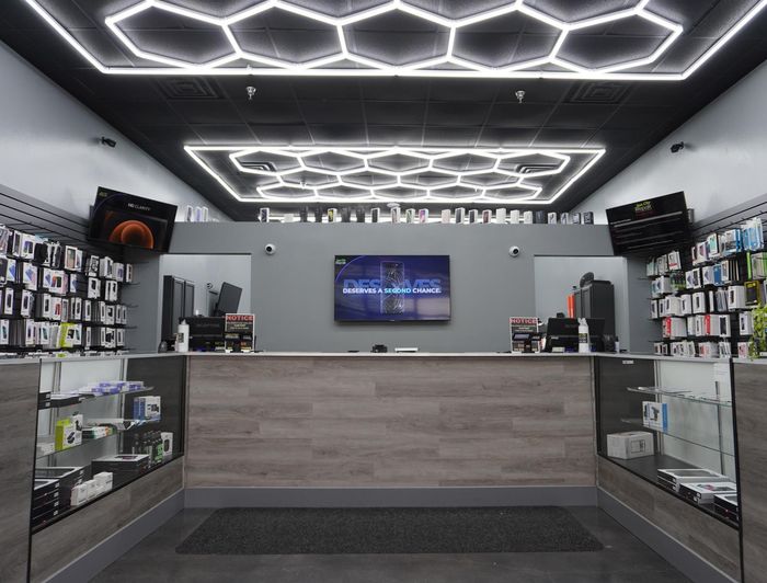 The inside of a store with a counter and a tv on the wall.