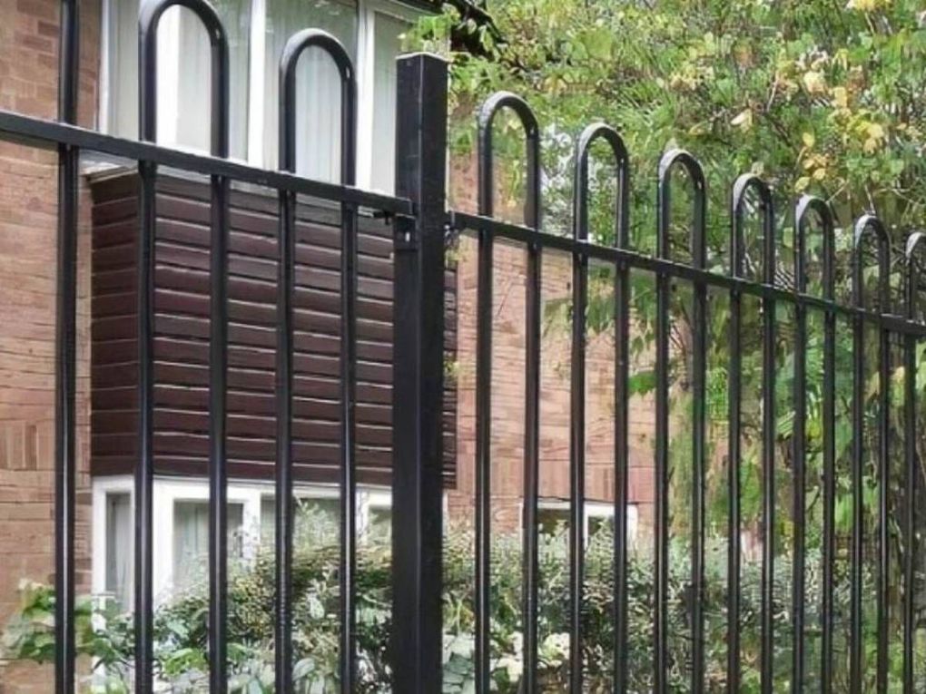 Black bow-top railings with square posts in front of a house