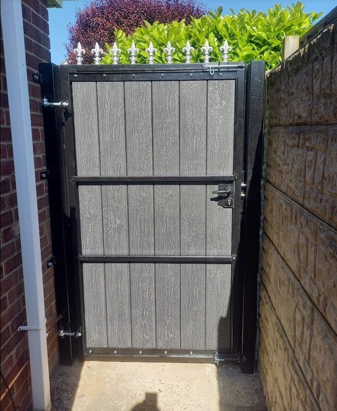 Grey composite side gate in a black frame with silver fleur de lis toppers