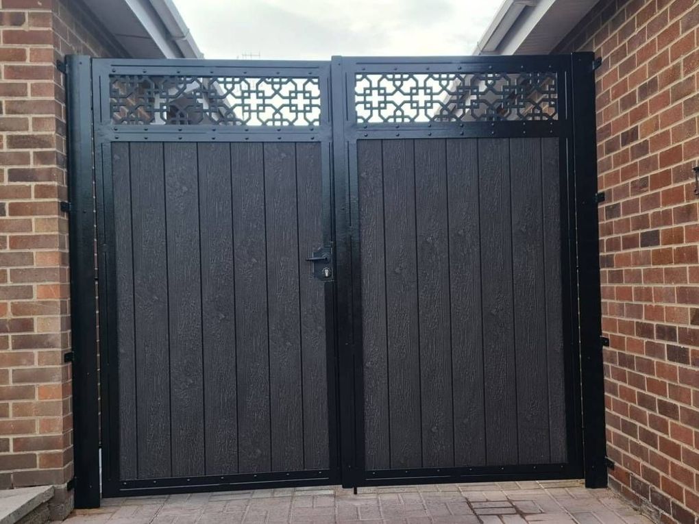 Grey composite double gates in a black steel frame with a decorative trellis top