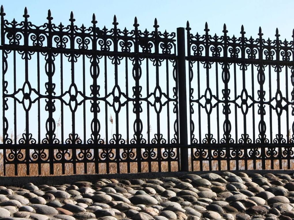 Example of ornamental black metal fencing with decorative cast-style panels and finials