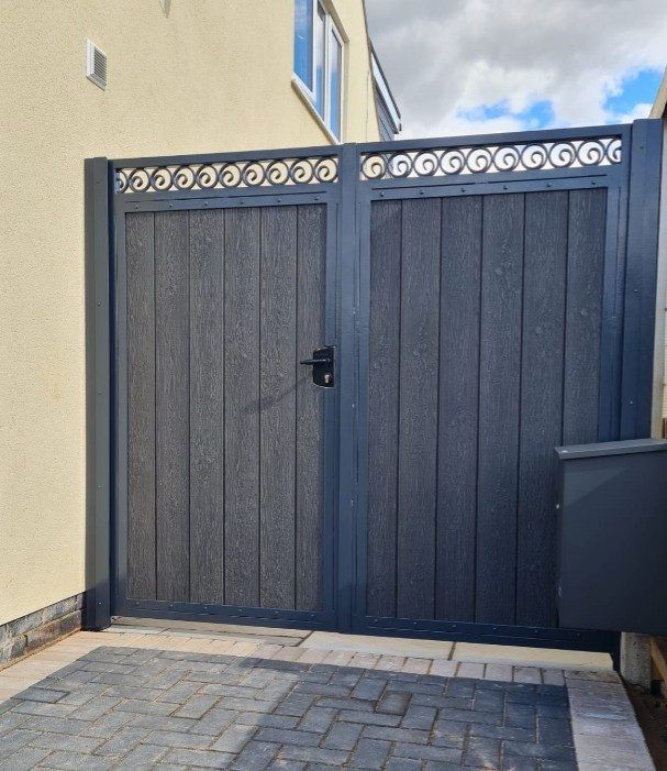 Double composite gates in an anthracite grey frame with a row of scrolls along the top rail