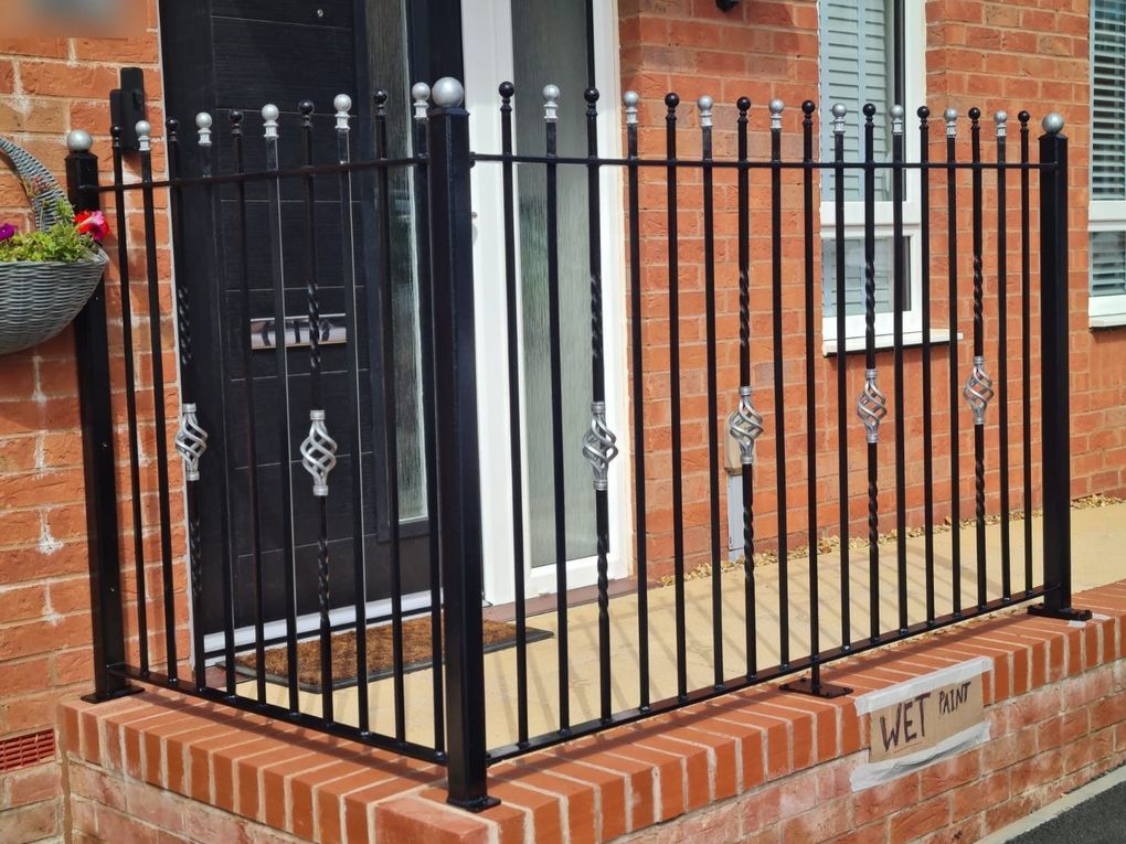Black ball-top railings with twisted bars and silver basket twists on a front garden wall