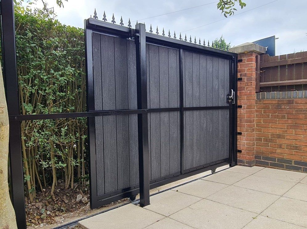 Inside view of a black composite sliding gate, showing the steel frame bracing and the runner along the bottom