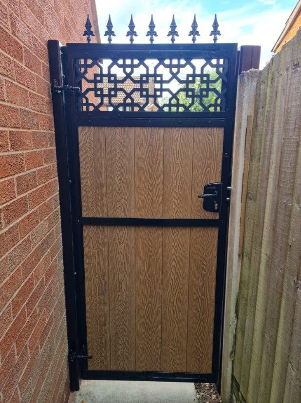 Light oak-effect garden gate in a black steel frame with a cathedral-arch trellis top