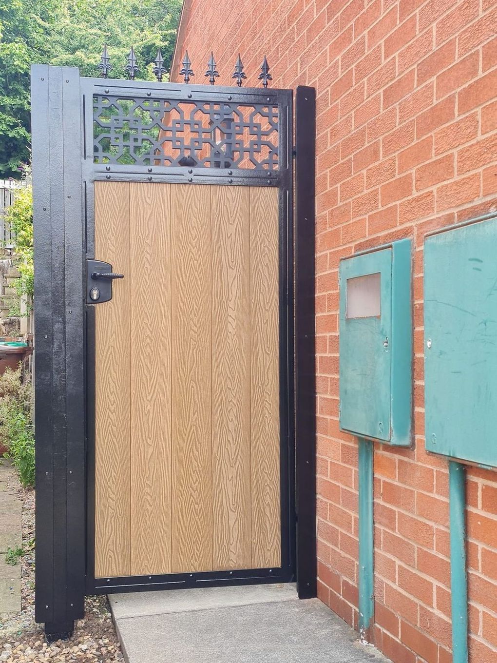 Light oak-effect composite side gate with a cathedral-pattern trellis top and spear toppers
