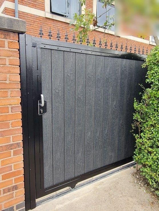 Black composite sliding gate with a row of spear toppers along the frame