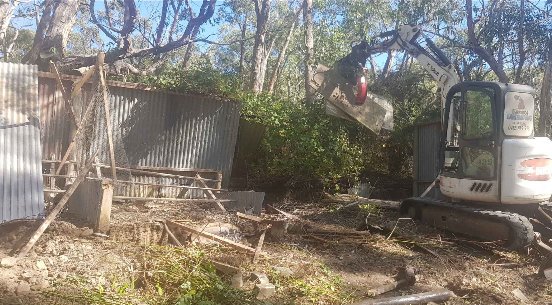 A Small Excavator Is Being Used To Demolish A Building In The Woods — Blackwood Earthmoving