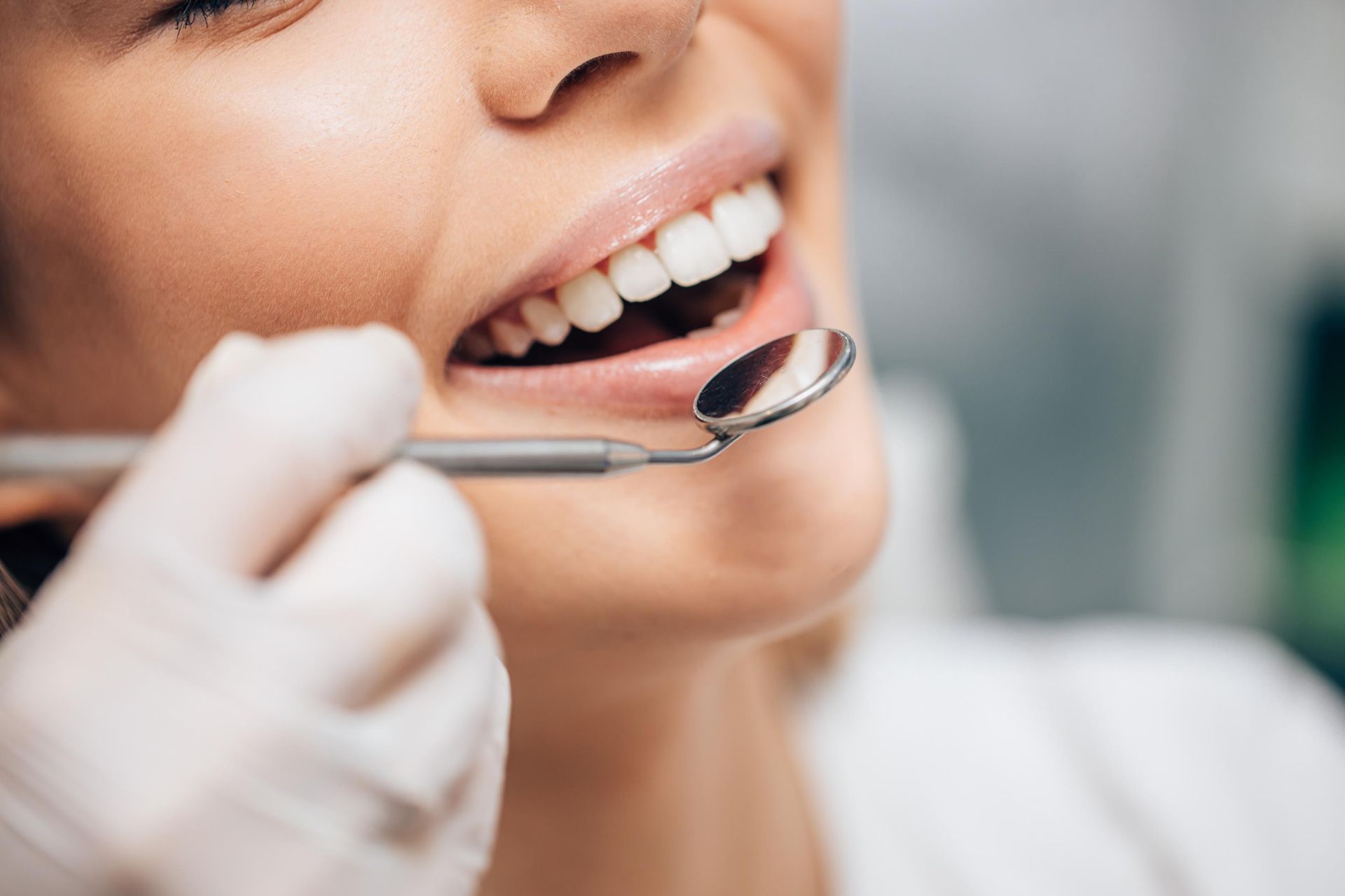 A woman is getting her teeth examined by a dentist.