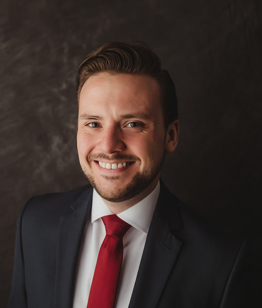 A man in a suit and tie is smiling for the camera.